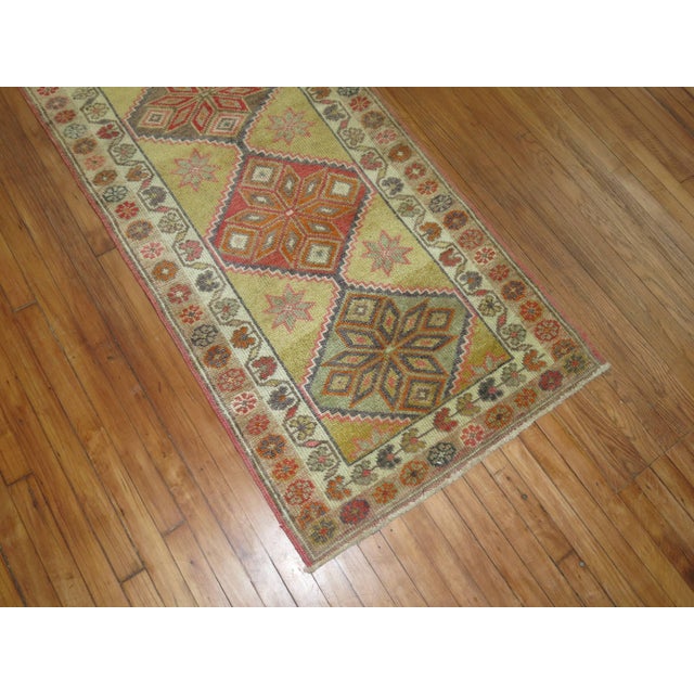Casual mid-20th century Turkish Anatolian runner. Green yellow gold field with multiple accent colors. Measures: 2'11" x...