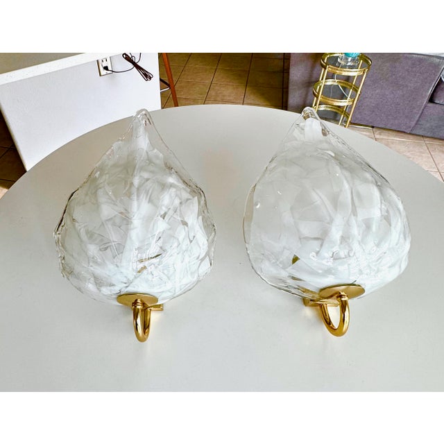 Pair of Mazzega Murano Italian handblown clear and white leaf shaped wall sconces mounted on brass wall plates. Newly...