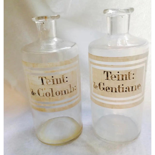 A beautiful pair of late 19th-century French pharmacy bottles, dating to approximately 1880–1900. Mouth-blown in clear...