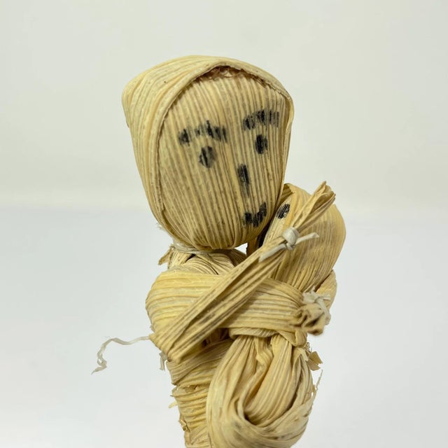 This Handmade corn husk mother and child from Zimbabwe depicts a working mother carrying her child and a load of wood....