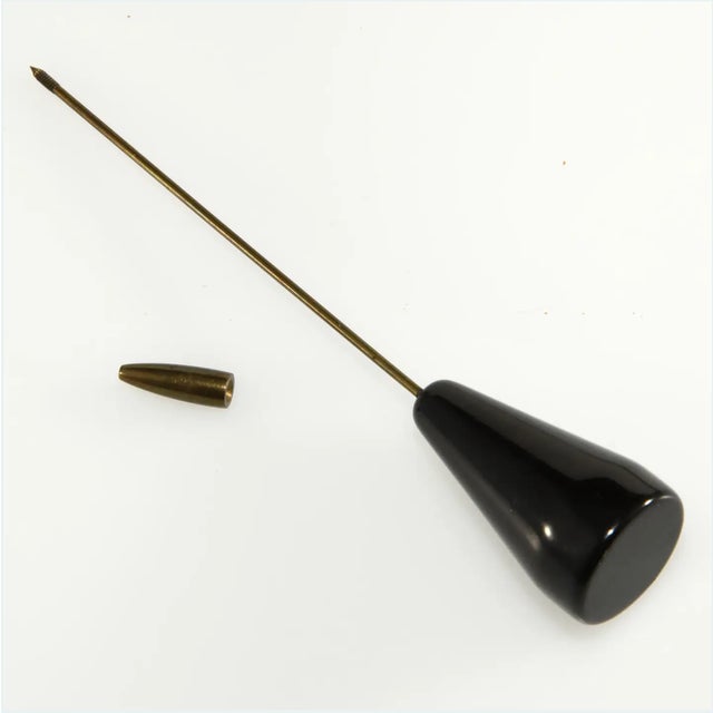 Jabot pin brooch or hat pin ornament made of black Bakelite. Nib on end unscrews to fasten. Unmarked. Measures 4 1/2" long...