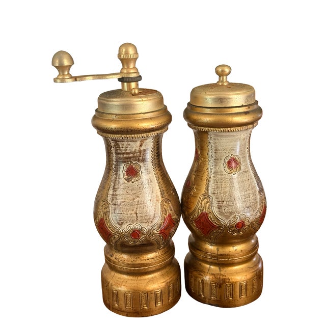 An exceptionally decorative vintage Italian salt shaker and hand-cranked pepper mill featuring elaborate Baroque Revival...