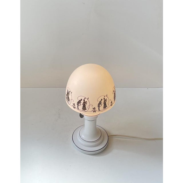 A rare milk-glass mushroom shaped table light with its original 1930s hand-painted shade featuring a series silhuets. from...