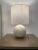 A perfectly spherical ceramic base and a cylindrical linen shade create a beautiful, airy modern table lamp for those...