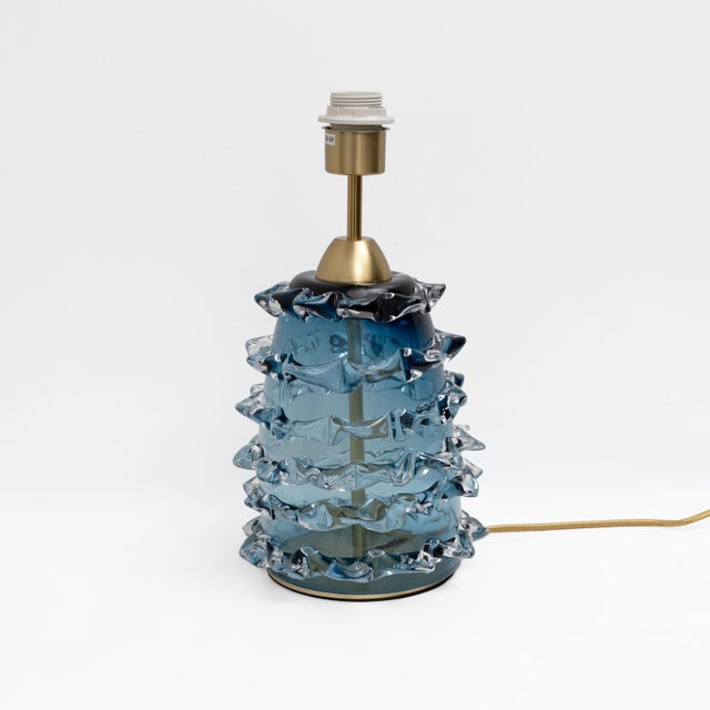 Elegant pair of table lamps featuring cylindrical bodies crafted from blue-coloured Murano glass using the refined...