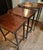 Elegant antique British nesting tables are made of mahogany with a rich finish. Each table has a rectangular top with a...