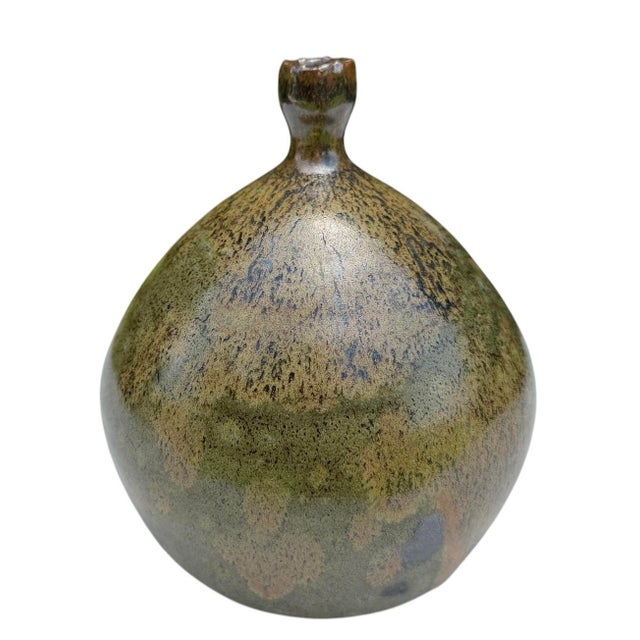 A beautifully handcrafted studio pottery bottle vase featuring a rounded sculptural form finished in layered moss green,...