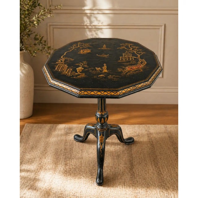 An exceptional Maitland-Smith Chinoiserie tilt-top table, masterfully hand-painted and richly detailed in gilt over a deep...
