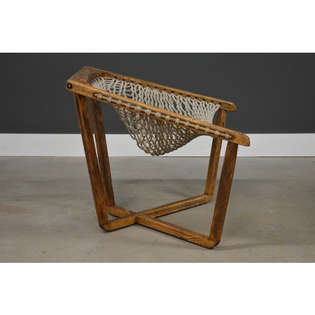 A solid oak frame net chair with a woven rope seat. Made in USA. Circa 1970’s. Seat height is 16”. 31.75” wide. 29” deep....