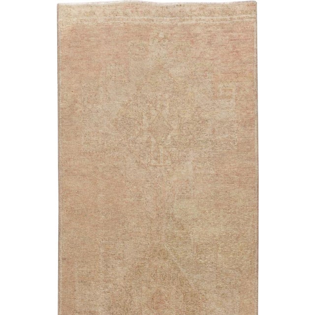 This mid-20th-century Turkish Anatolian long runner presents an exceptionally restrained composition in softly blended...