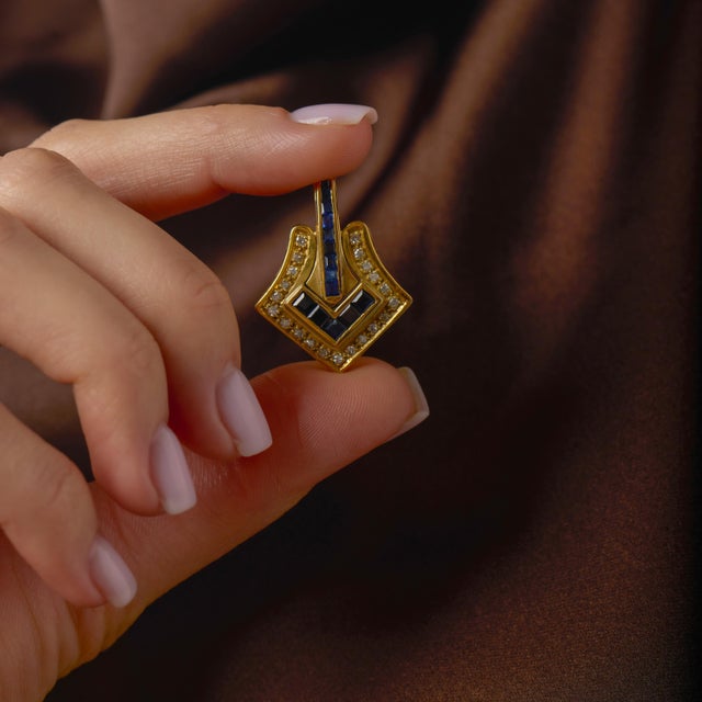 This striking vintage pendant is a bold yet refined expression of classic gemstone design, combining rich blue sapphires...