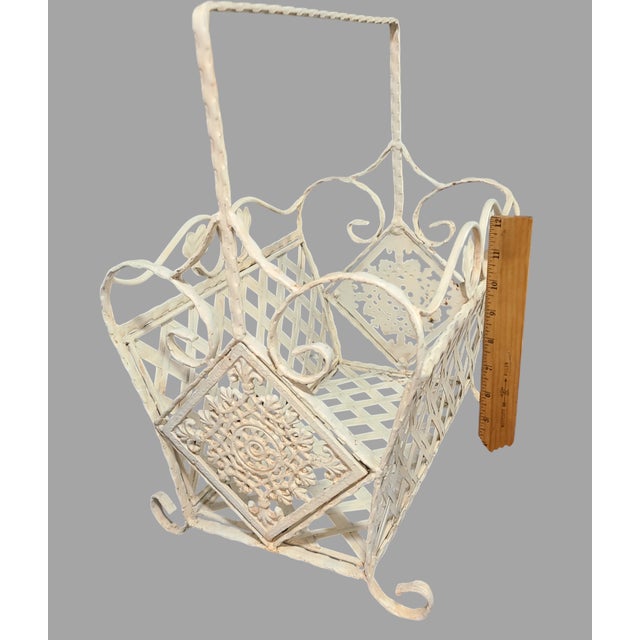 Add a touch of vintage French elegance to your living space with this beautiful painted white wrought iron magazine rack....