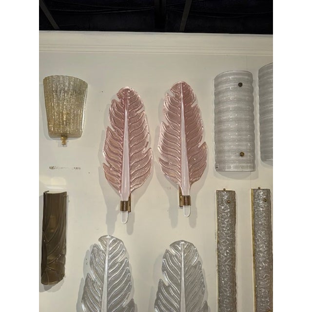 This listing features a pair of modern Murano glass leaf form sconces, frosted in a pink finish. The sconces are crafted...