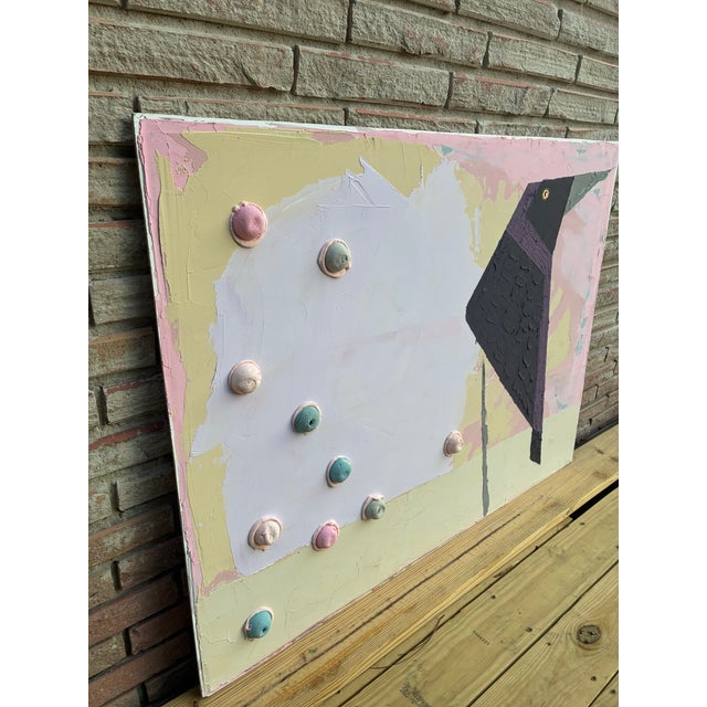 A dark raven, still and sharp, anchors a serene canvas of pastel colors. A quiet contradiction is found in the unexpected...