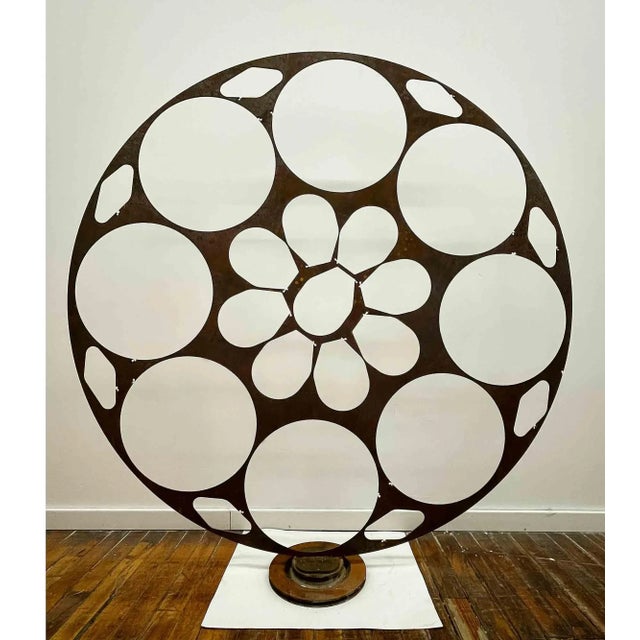Large iron abstract sculpture on iron base. Cutout circles and interdispersed geometric shapes.