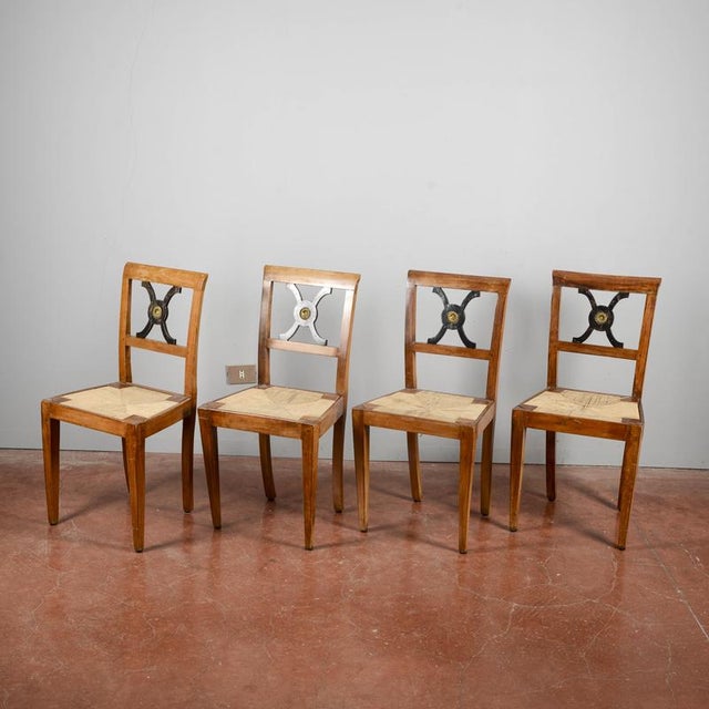 A charming set of four wooden chairs, dating from the late 19th or early 20th century, recalling the classical or...