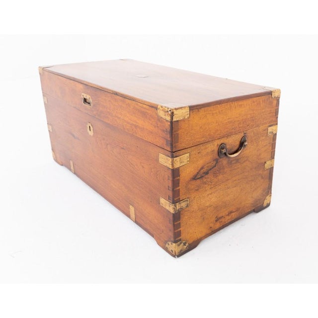 A handsome camphor wood military campaign trunk featuring impressive brass strapwork and sturdy carrying handles Circa...