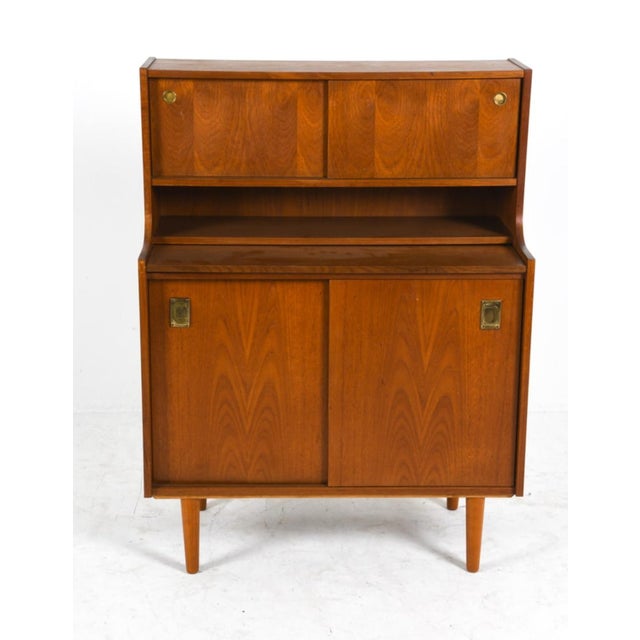 Mid-century Danish secretary cabinet produced by Winge Møbler, Denmark, circa 1960s. Constructed in teak with consistent...