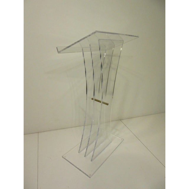 A very sculptural Lucite and brass lectern podium or hostess stand, this high end piece has three graduating uprights with...