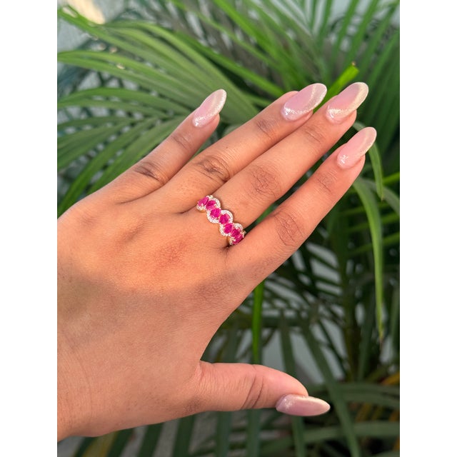 This half band ring features a 1.91 carat pear cut rubies, set in 14K yellow gold. Each measuring approximately 4.52 x...