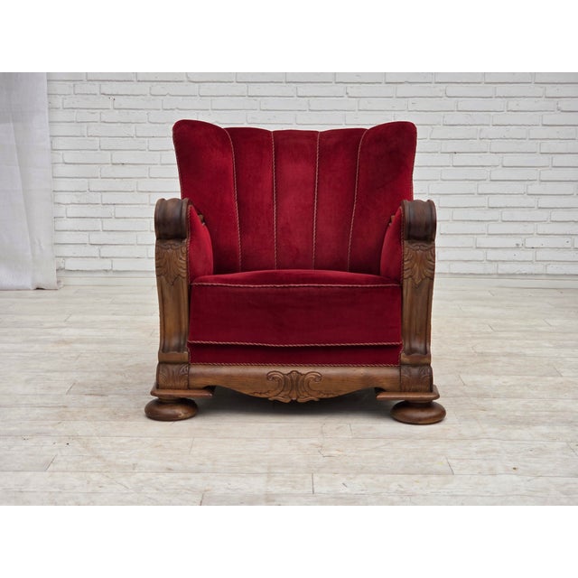 1950s, Danish relax armchair. Red furniture velour, carved oak wood, brass springs in the seat. The chair was...