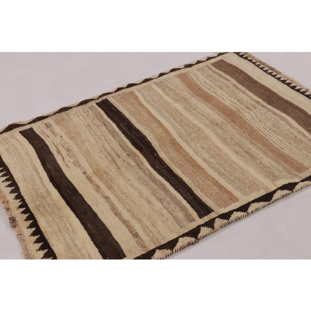 Hand-knotted in wool circa 1950-1960, this 4x5 vintage Persian Gabbeh rug is a masterclass in organic minimalism. Part of...