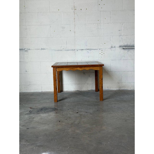 This charming square coffee table features an inset ceramic tile top and classic turned legs. Built with traditional...