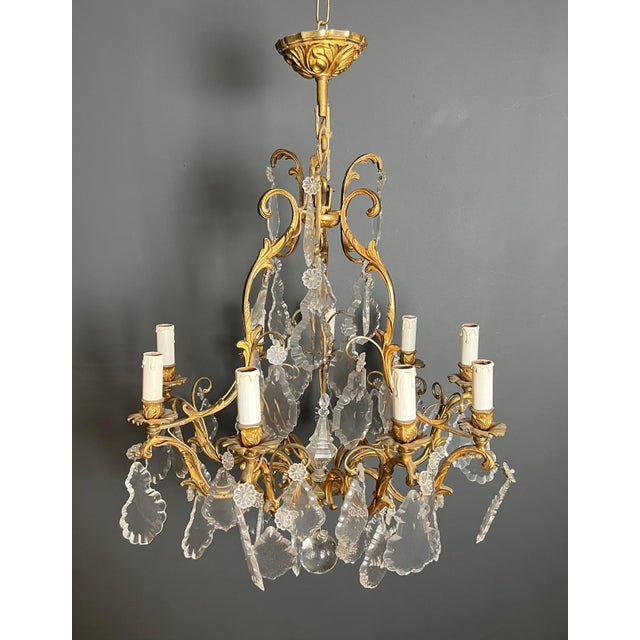 This highly decorative chandelier is made of crystal and bronze. It is a French work in the Louis XV style. Circa 1900