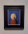 In "Goodbye Children," a stylized figure emerges against a vivid blue background, its oversized, smooth head presenting a...
