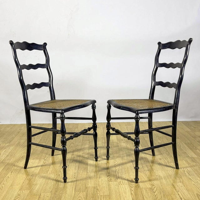 This pair of rustic ladder-back chairs evokes the timeless charm of traditional vintage furniture. Featuring a wave-...