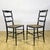 This pair of rustic ladder-back chairs evokes the timeless charm of traditional vintage furniture. Featuring a wave-...