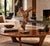 An abstract free-form sculpture crafted from natural weathered teak wood, showcasing organic shapes, hollow voids, and a...