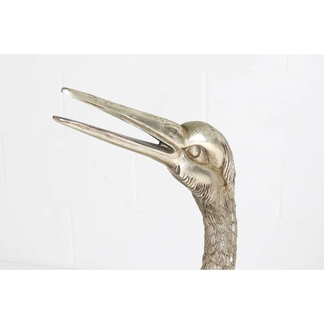 A striking and highly decorative pair of monumental crane sculptures, executed in silvered metal—likely silvered bronze or...