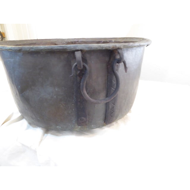 This 19th Century verdigris copper cauldron has iron handles, some strips of felt were glued to the bottom to protect the...