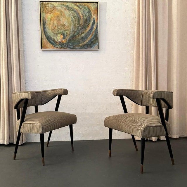 This pair of chic Hollywood Regency armchairs circa the 1950s strike a sophisticated pose from every angle. The pair...
