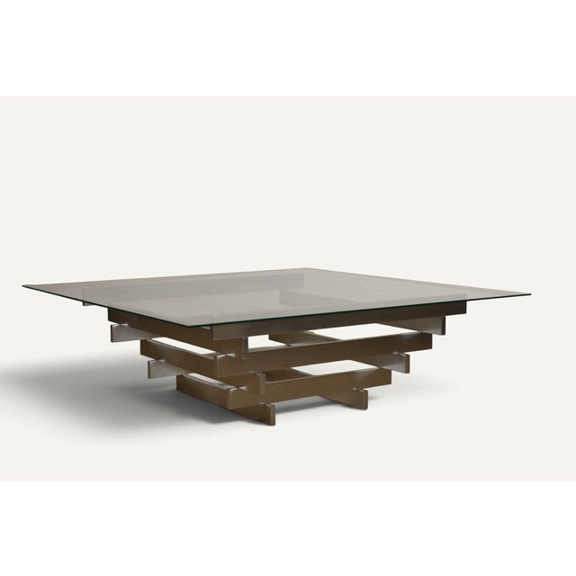 Elegant vintage coffee table from the 1970s, characterized by a striking geometric construction in brushed metal and a...