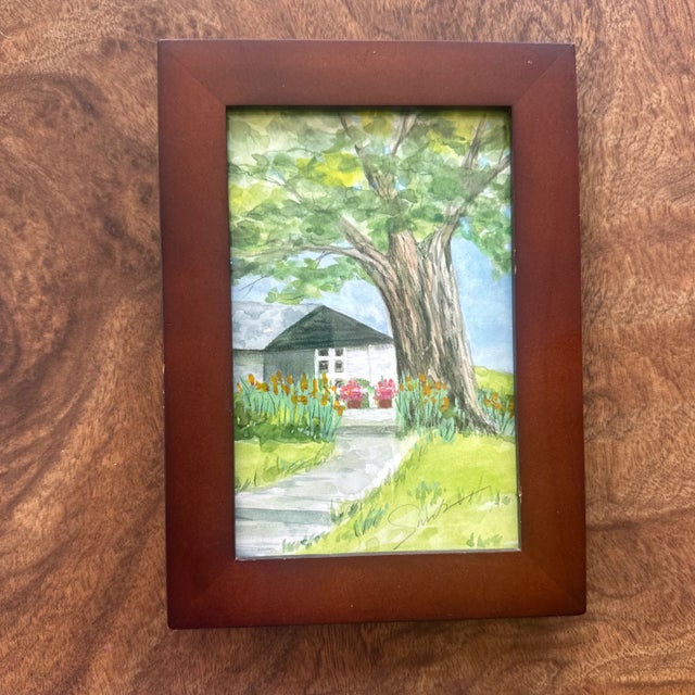 Step into a serene garden path shaded by a large tree in this charming watercolor landscape. A white cottage peeks through...