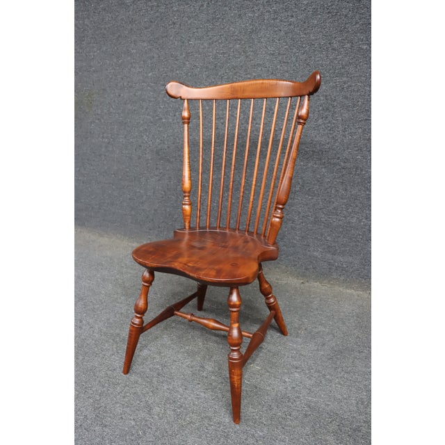Bench made Windsor chair in tiger maple with a shaped saddle seat and high spindle back. Features a curved crest rail,...