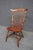 Bench made Windsor chair in tiger maple with a shaped saddle seat and high spindle back. Features a curved crest rail,...