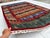This hand-knotted Khorjin rug features a vivid patchwork of horizontal bands in rust, blue, gold, and green, each filled...