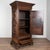 Early 19th century French single door armoire cabinet, crafted in walnut. Heavy carving adorns the three panels of the...