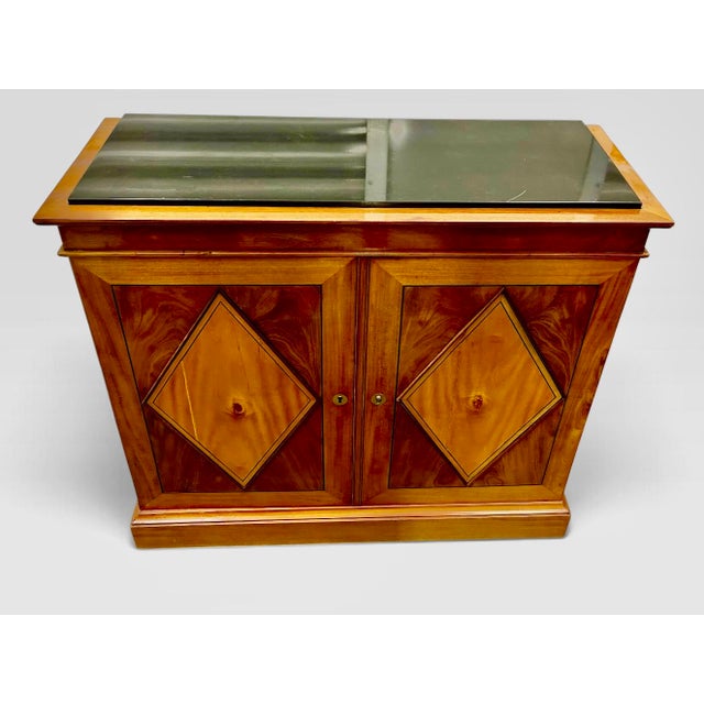 A handsome French commode à vantaux et tiroirs, having a rectangular case surmounted by an inset slab of black Belgian...