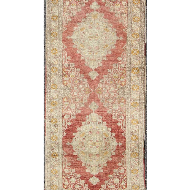 Measures: 3'2 x 10'6. Antique Turkish Oushak Runner with Faded Red Medallions and Soft Ivory. Keivan Woven Arts / rug...