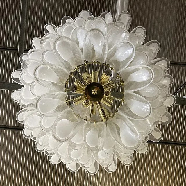 Brass chandelier with transparent murano and opaque murano glass elements applied in six overlapping tapered rings. 18 E14...