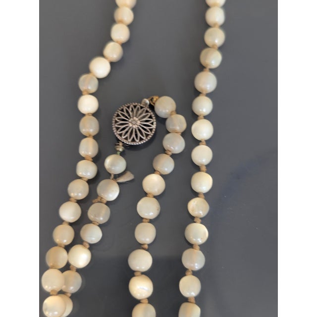 Rare 60" long antique single strand beaded shell necklace with ornate sterling silver clasp. The clasp is of Victorian...
