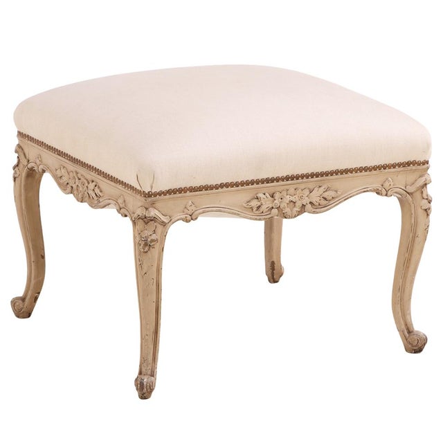 The stool features a rectangular shaped seat supported by cabriole legs with carved detailing, reflecting the graceful...