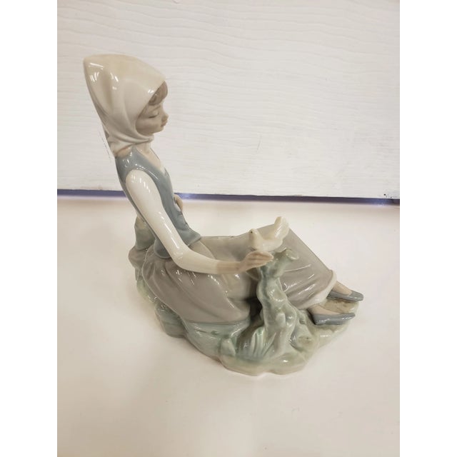 This is a Vintage Lladro Shepardess Girl Sitting with Dove Porcelain Figurine. It measures 6 1/2" high x 6 1/2" deep x and...