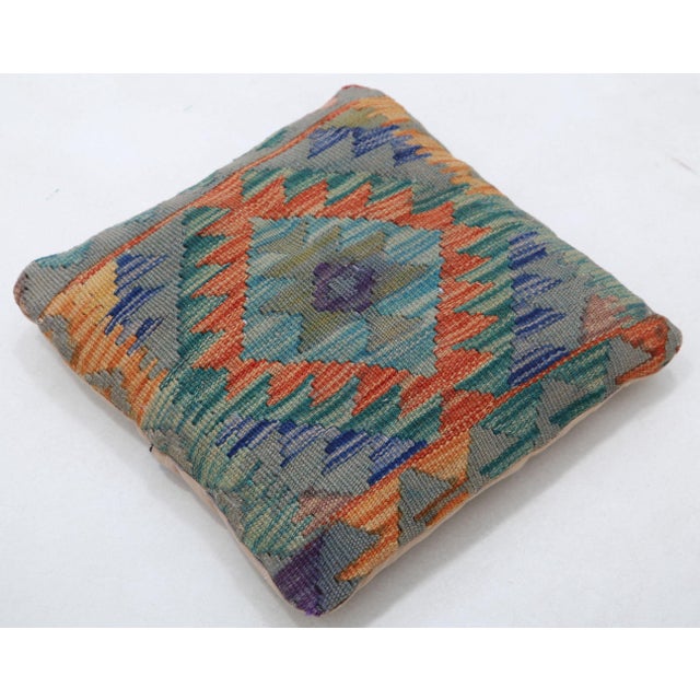 A one-of-a-kind handwoven Afghan wool kilim accent pillow featuring diamond medallion with triangles on a slate ground....