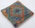 A one-of-a-kind handwoven Afghan wool kilim accent pillow featuring diamond medallion with triangles on a slate ground....