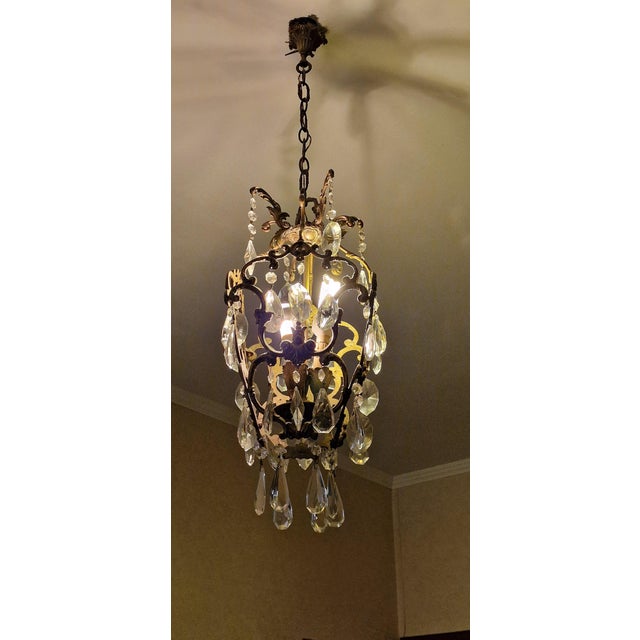 Crystal chandelier from around 1940, with a cage structure made of hot-shaped square-section brass tubing. The structure...